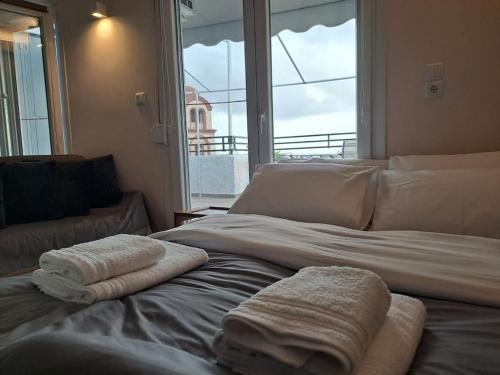 1 cama con toallas y ventana en Parkview Central Apartment - Xanthi, en Xanthi