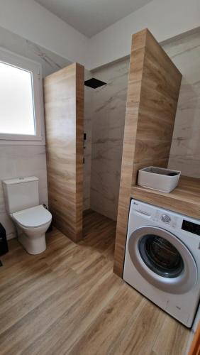 uma casa de banho com uma máquina de lavar roupa e um WC em Nala's home em Porto Heli