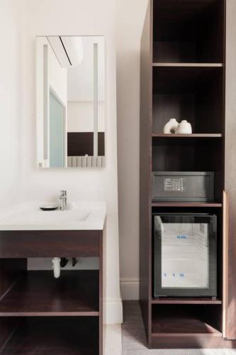 a bathroom with a sink and a mirror and a counter at Rove Hotel London Paddington in London