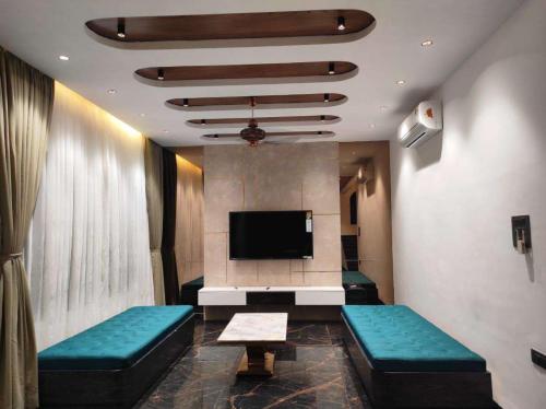 a waiting room with couches and a flat screen tv at Curtis House in Hyderabad