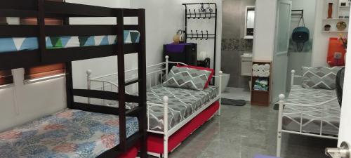 Zimmer mit 2 Etagenbetten und einem Sofa in der Unterkunft Virtuoso in Pasong Mannga