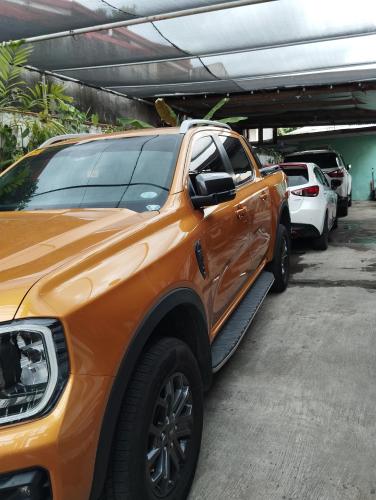 an orange truck parked in a parking lot at 10 to 16 Pax - Unit 1&2 in Pasong Mannga