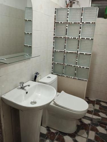 a bathroom with a white toilet and a sink at 10 to 16 Pax - Unit 1&2 in Pasong Mannga