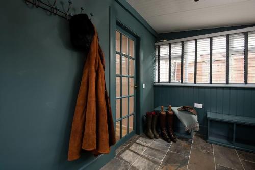 a blue room with boots on the wall at Bughtrig Cottage in Coldstream