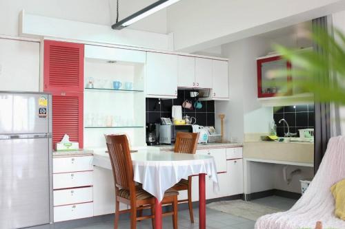 a kitchen with a table and two chairs and a refrigerator at Cozy 1br walk to BTS and Airport Rail Link Close to Malls T in Bangkok