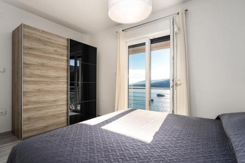 a bedroom with a bed and a large window at Astrid 2 in Rabac