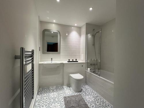 a bathroom with a tub and a toilet and a sink at Delightful & Spacious Flat in London - Peckham in London