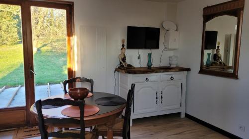 ein Esszimmer mit einem Tisch und einem Spiegel in der Unterkunft Aux Nobles Acacias in Épagne-Épagnette