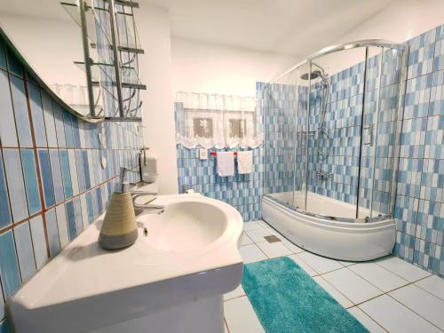 een blauwe en witte badkamer met een bad en een wastafel bij Villa Sabina in Fužine