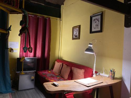a living room with a red couch and a table at Artist's Place Trat in Trat