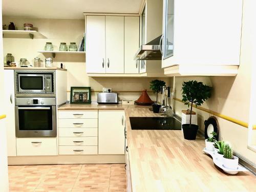 a kitchen with white cabinets and a counter top at Primera Linea de Playa con vistas al Mar in Águilas