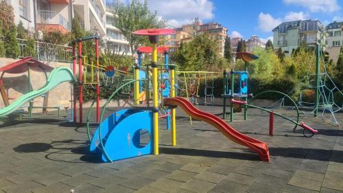 a playground with a slide and a play structure at Sun Wave Sea and Pool View in Sveti Vlas