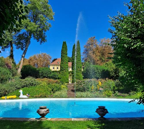 einen Pool in einem Garten mit einem Brunnen in der Unterkunft Ferienwohnung Ottmanach Schlosshof in Pischeldorf