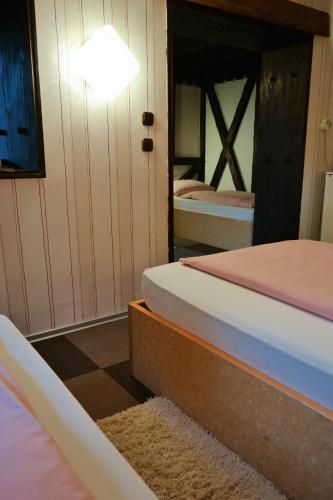 a bedroom with two beds and a light on the wall at Am Hallenbad Hotel garni in Ratingen