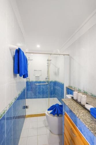a bathroom with a toilet and a shower with blue tiles at 3 Bedroom Villa Cara SDV042-By Samui Dream Villas in Mae Nam