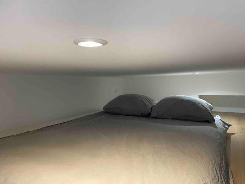 une chambre avec un lit avec deux oreillers dessus dans l'établissement Bright studio apartment in the heart of Paris, à Paris