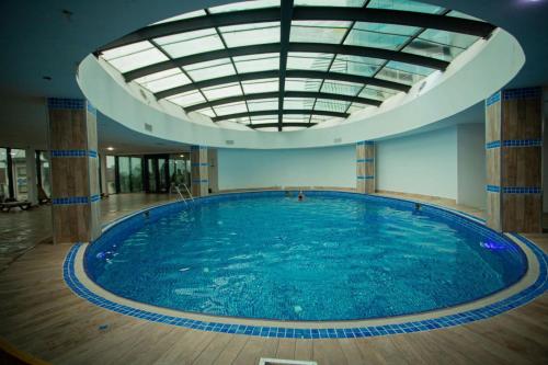 une grande piscine avec un grand plafond dans l'établissement Orbi City ApartHotel, à Batoumi