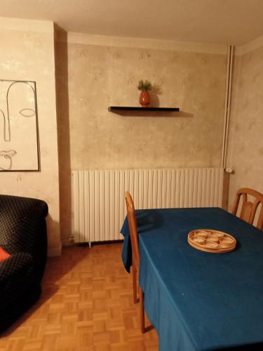 a table with a blue table cloth and a plate on it at Entre Bresse et Jura in Bellevesvre