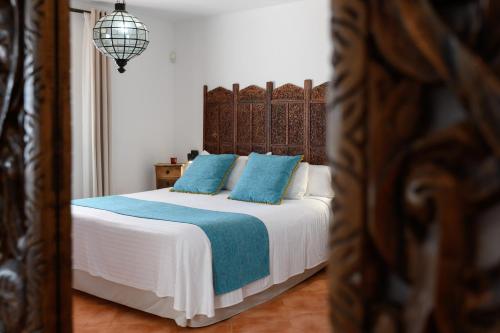 a bedroom with a bed with blue pillows at Villa Golf Lanzarote in Costa Teguise