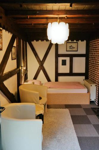a bedroom with a bed and a chair and a chandelier at Am Hallenbad Hotel garni in Ratingen