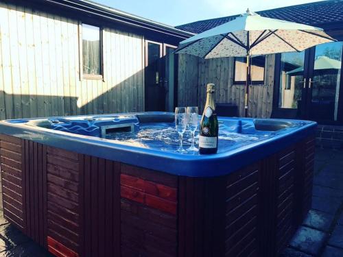 a hot tub with a bottle of champagne in it at Yellowrush Lodge @ Yellowtop in Selby