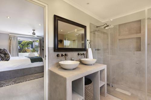 a bathroom with two sinks and a shower at Rancho Relaxo in Bloubergstrand