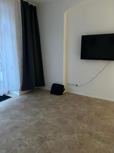 a room with a flat screen tv on a wall at Apartment in Stadtzentrum Oelsnitz in Oelsnitz