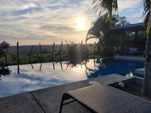 a pool with a table and the sunset in the background at La Maracuya Panama in Playa Coronado