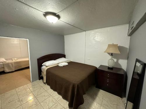 - une chambre avec un lit et une commode avec une lampe dans l'établissement 1BR Plus Basement, Near Beach and Restaurants, à San Juan