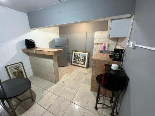 a small kitchen with a counter and a refrigerator at 1BR Plus Basement, Near Beach and Restaurants in San Juan