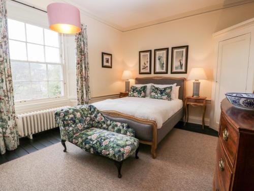 a bedroom with a bed and a chair at Harmony House - Harmony Gardens in Melrose