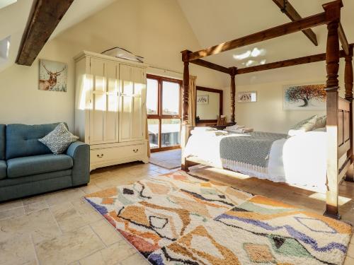 a bedroom with a large bed and a blue couch at Brambleberry Barn in Spilsby