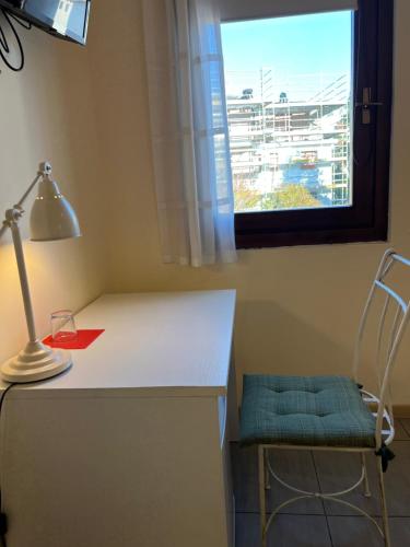 a desk with a lamp and a chair next to a window at Cà Dei Barcaroli in Mestre