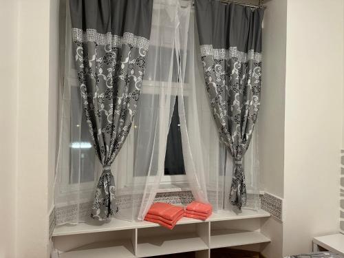 a window with black and white curtains and red pillows at Penzion Sokolov in Sokolov