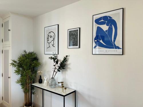 un salon avec trois photos sur le mur et une table dans l'établissement L'horizon - Spacieux et idyllique t3, à Poitiers