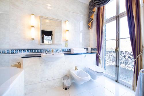 a bathroom with two sinks and a toilet and a mirror at The Central Hotel in Scarborough