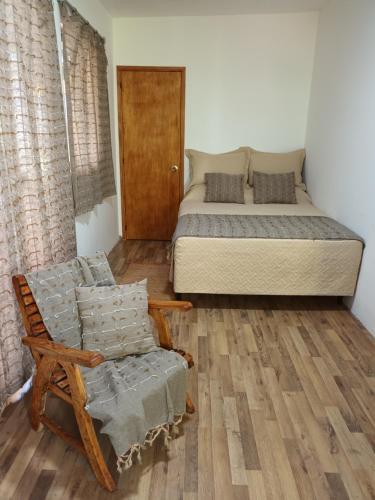 a bedroom with a bed and a chair and a bed at Leia's House in Colonia del Sacramento
