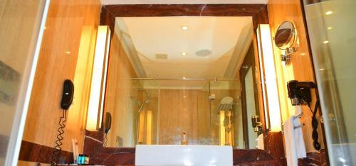 a bathroom with a sink and a mirror at Anandha Inn Convention Centre and Suites in Pondicherry