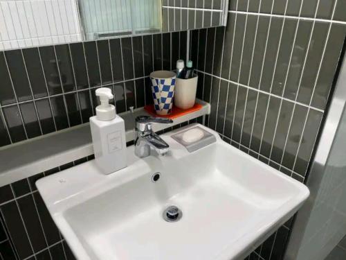 a bathroom sink with a soap dispenser on it at feel at home in Daegu