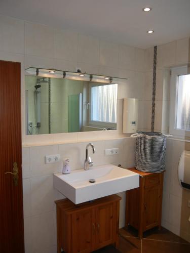 La salle de bains est pourvue d'un lavabo et d'un miroir. dans l'établissement Ferienhaus Baarsen 30, à Bad Pyrmont