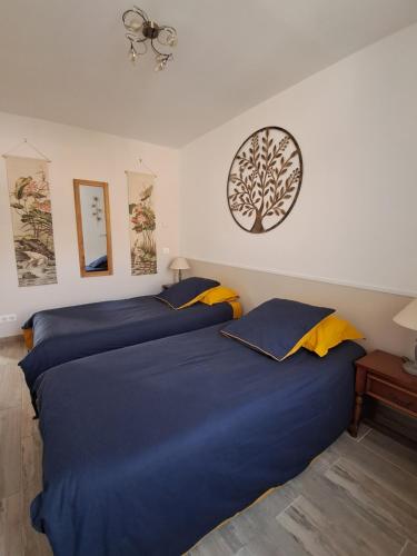 twee bedden naast elkaar in een slaapkamer bij MAISON LONGERE LES CAMELIAS in Vinneuf