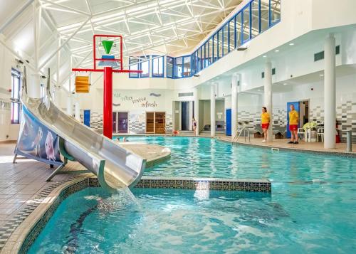 a swimming pool with a slide in a building at Stanwix Park in Silloth