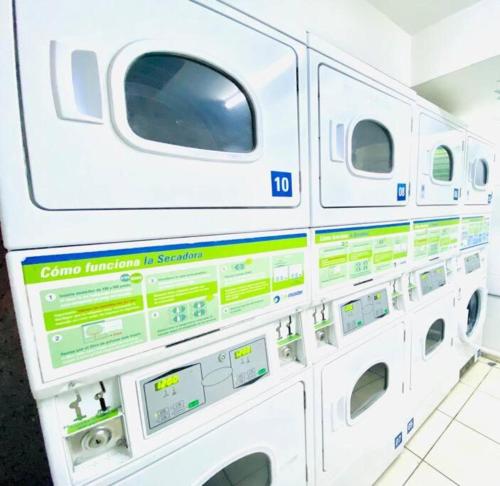 eine Reihe weißer Waschmaschinen in einem Zimmer in der Unterkunft Departamento de 1 Dormitorio, in Santiago