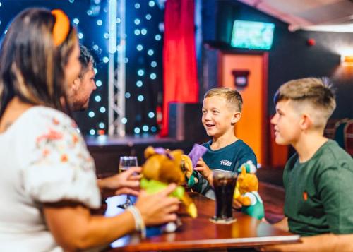 a woman and two boys sitting at a table with stuffed animals at Thurston Manor in Innerwick