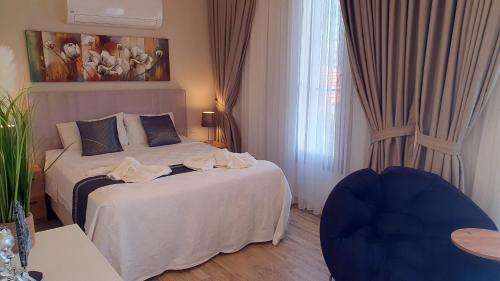 ein Schlafzimmer mit einem Bett und einem blauen Stuhl in der Unterkunft Villa Vanilya in Dalyan