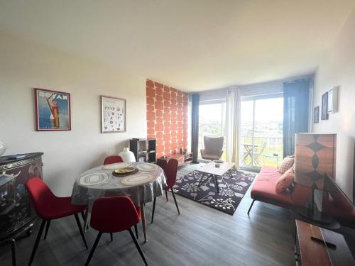 - un salon avec une table et des chaises rouges dans l'établissement Le Rétro - Splendide appartement, à Poitiers