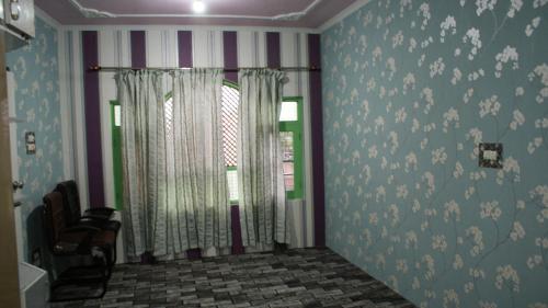 Zimmer mit gestreiften Wänden und einem Fenster mit Vorhängen in der Unterkunft Luminaire Homestay in Srinagar