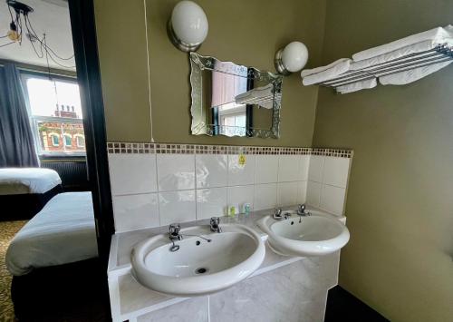 a bathroom with two sinks and a mirror at The Wrens in Leeds