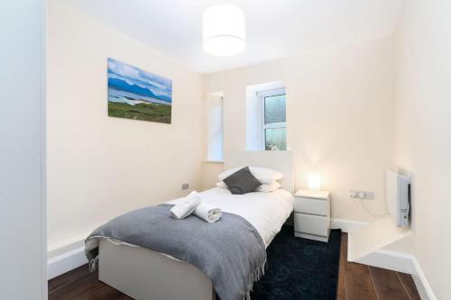 a white bedroom with a bed and a tv at Property 444 - Clifden in Clifden