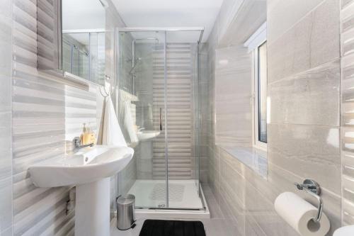 a white bathroom with a sink and a shower at Property 444 - Clifden in Clifden